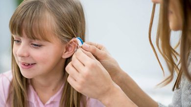 A little girl at a medical clinic getting a new hearing aid.